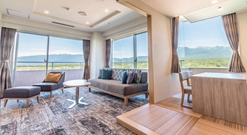 角部屋で窓から遠方の山並みが見える、リビングと和室部分が写った写真