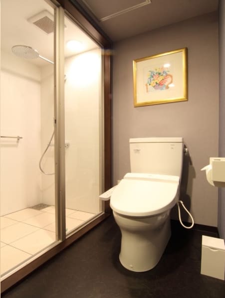 トイレの隣に、ガラス張りのシャワーブースが写る写真