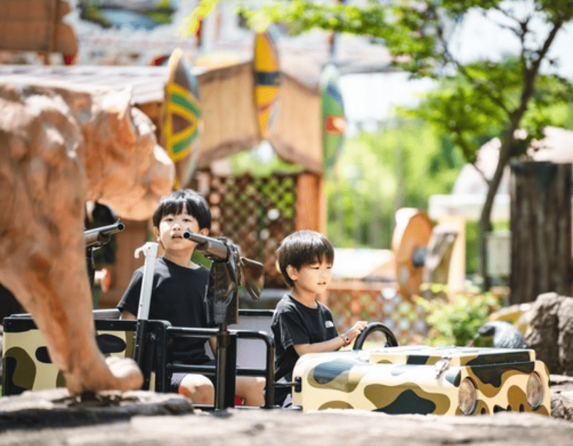 ライオンに銃を向けようとしている幼い兄弟の写真