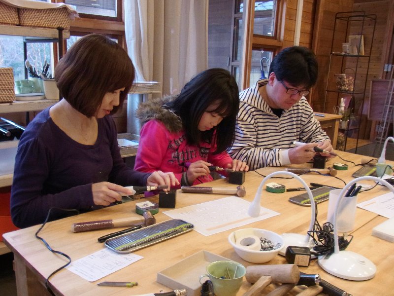 シルバーアクセサリー作りをしているママ・パパ・女の子の写真