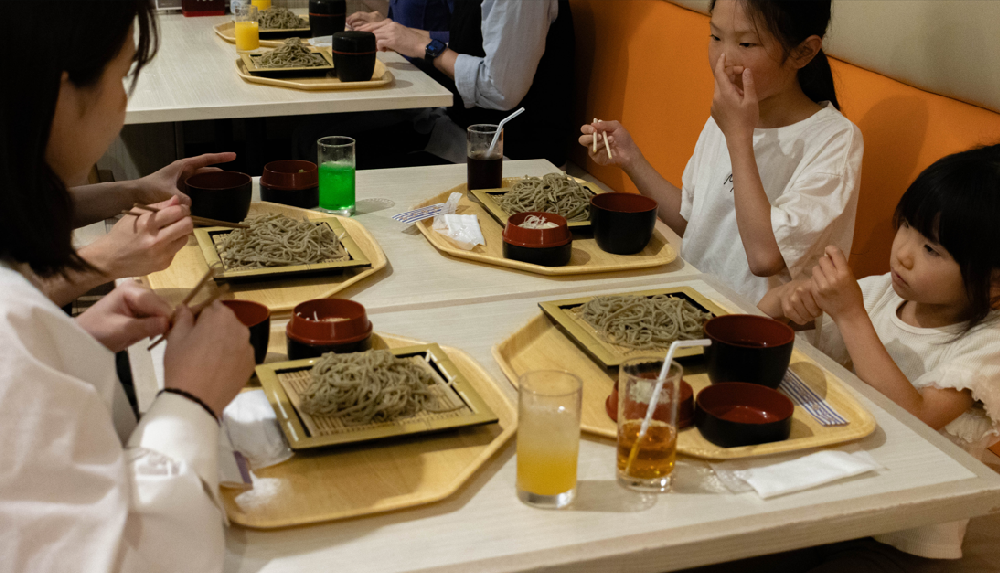 そばを食べる女の子２人とママの写真