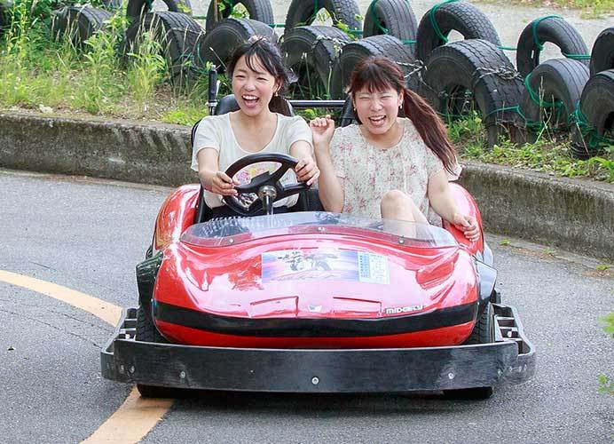 ゴーカートに笑顔で乗る女性2人の写真