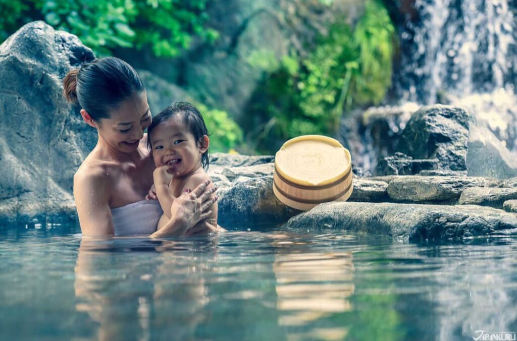 露天風呂に笑顔で入浴中の赤ちゃんとママの写真