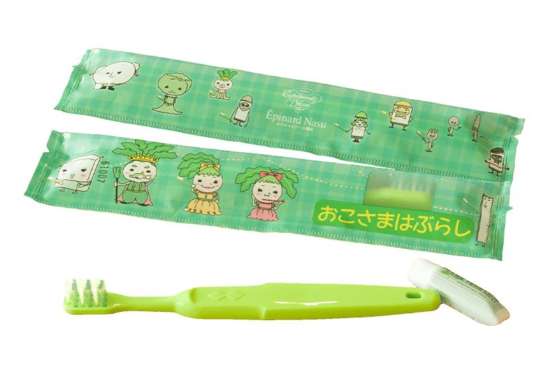 黄緑の子ども用歯ブラシと歯磨き粉