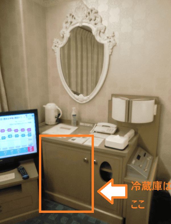 ホテル ヘリテイジ飯能の客室プリンセス内にある大きな鏡とポットや電話が乗った棚の写真