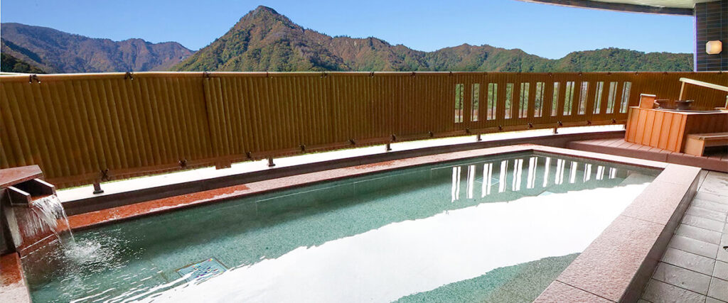 遠くに山が見える３階にある日中の露天風呂