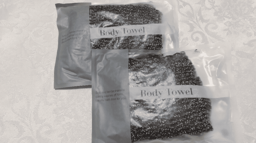 国済寺天然温泉　ハナホテル深谷&スパ　個包装に包まれた茶系のボディータオルの写真