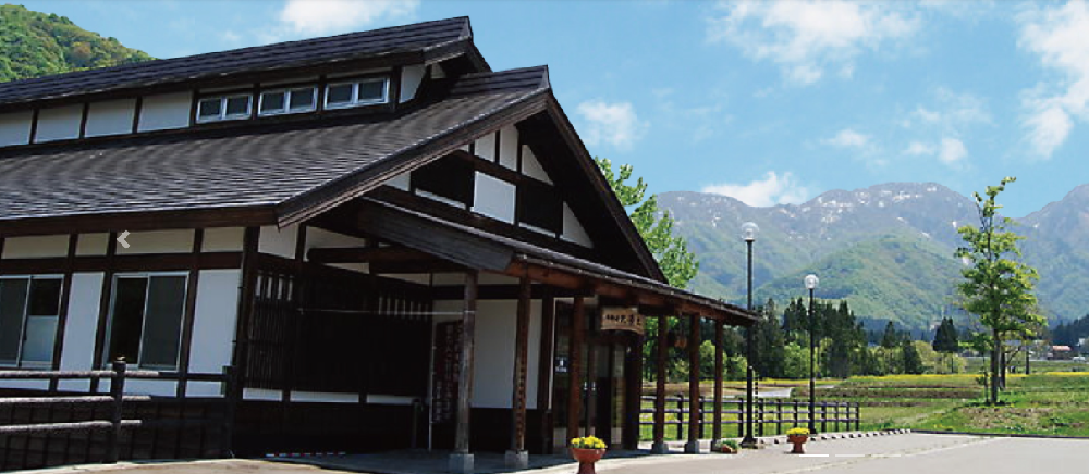 黒っぽい和風造の平屋の店の入口外観写真