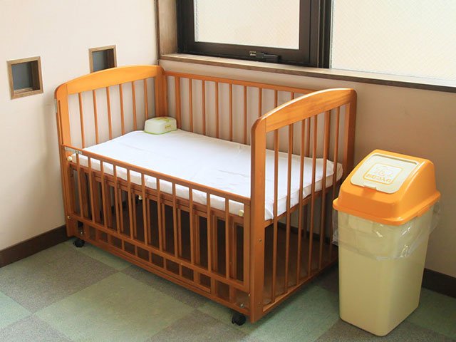 木製ベビーベッドとオムツゴミ箱が並んだ写真
