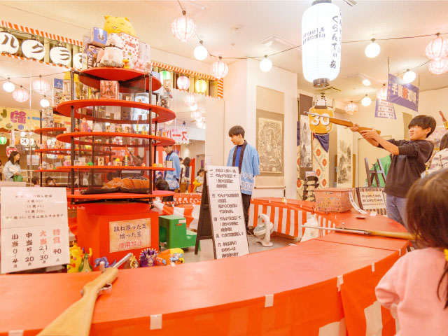 エンゼルグランディア越後中里 縁日にある射的をする男の子の写真