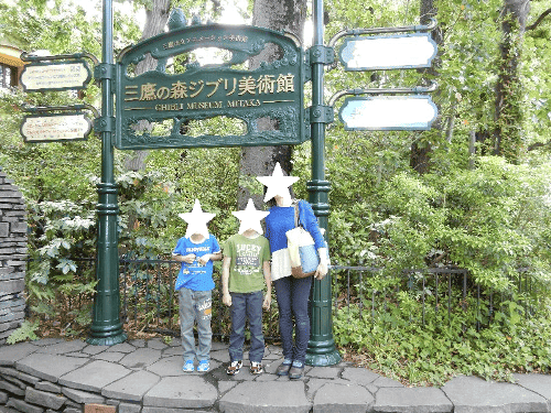 三鷹の森ジブリ美術館の門前で記念撮影する親子3人の写真