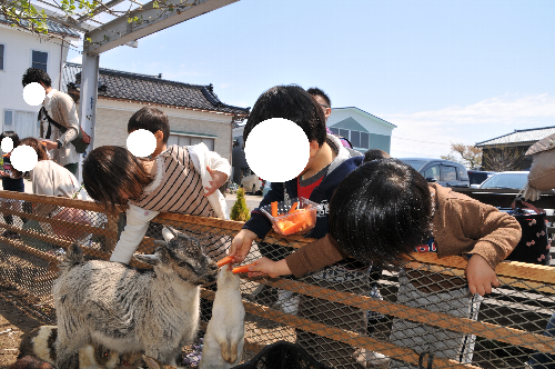 白根グレープガーデンのやぎにえさやりする幼い男の子たちの写真