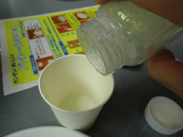 伊香保グリーン牧場　バター作り体験でビンの中に出来たミルクを紙コップに注いでいる写真