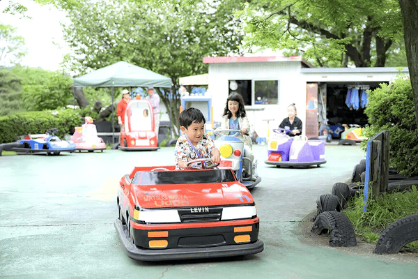 伊香保グリーン牧場内　こどもゆうえんち　バッテリーカー体験する子どもたちの写真